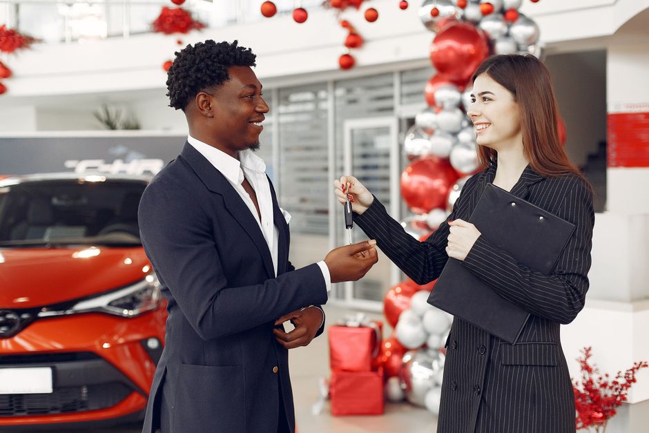 Car dealer handing over keys to a customer after a used car purchase