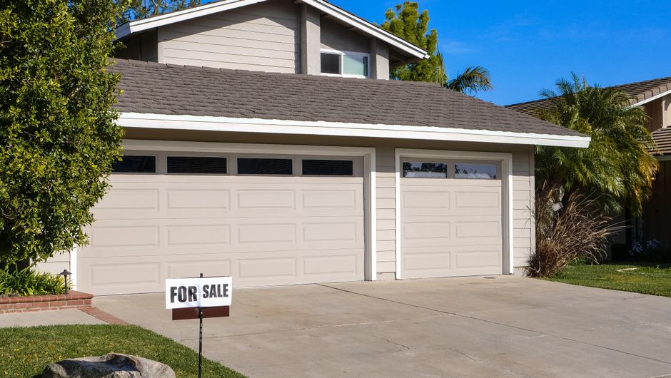 Seller showing a used car to a private buyer in a driveway for a private sale