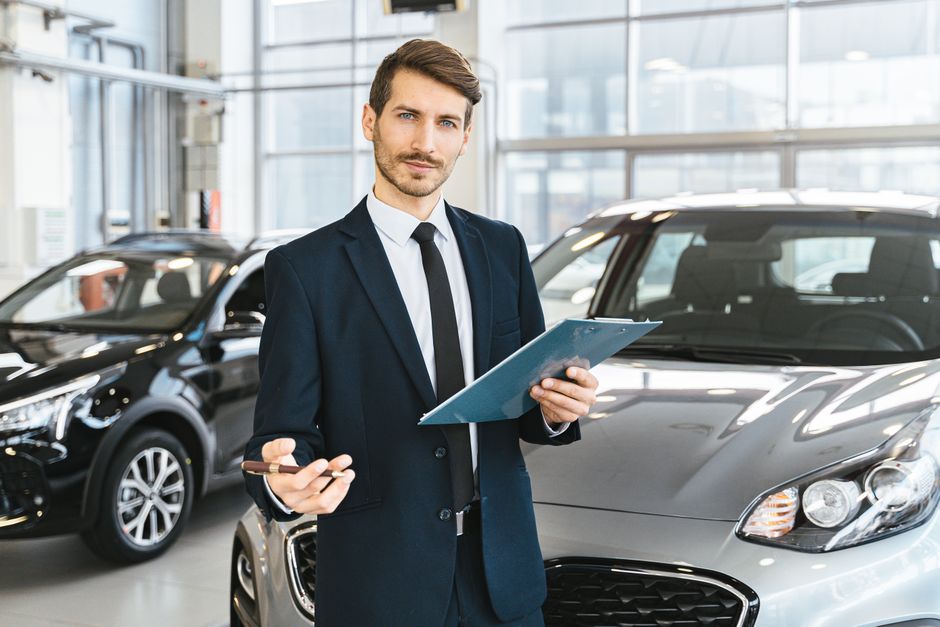 Dealer inspecting a used car's exterior to prepare the highest used car offer for the owner