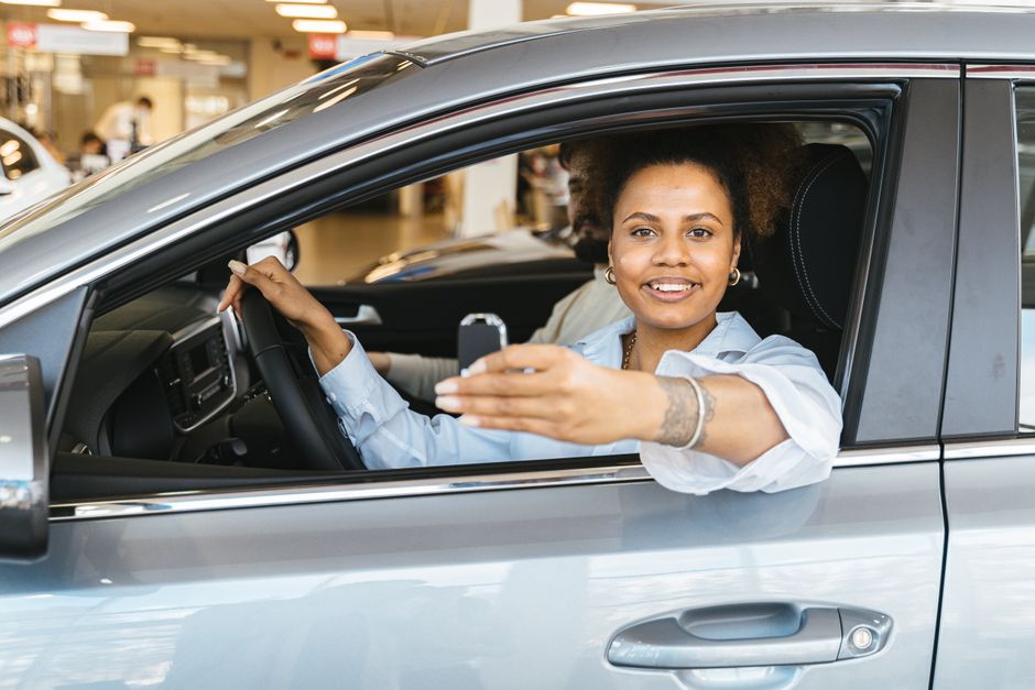 Dealer handing over car keys after financing approval at a used car lot