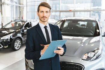 Dealer inspecting a used car outdoors while comparing max offer vs CarMax instant offer for the seller