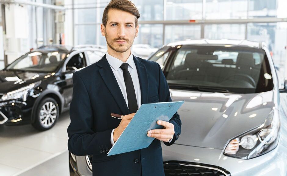 Dealer inspecting a used car outdoors while comparing max offer vs CarMax instant offer for the seller