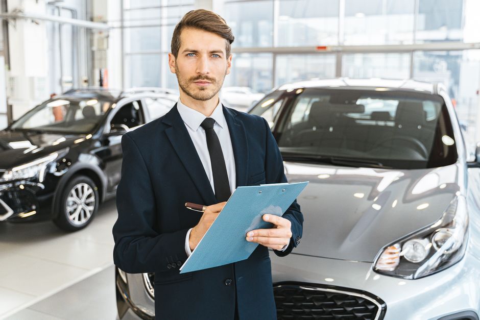 Dealer inspecting a used car outdoors while comparing max offer vs CarMax instant offer for the seller