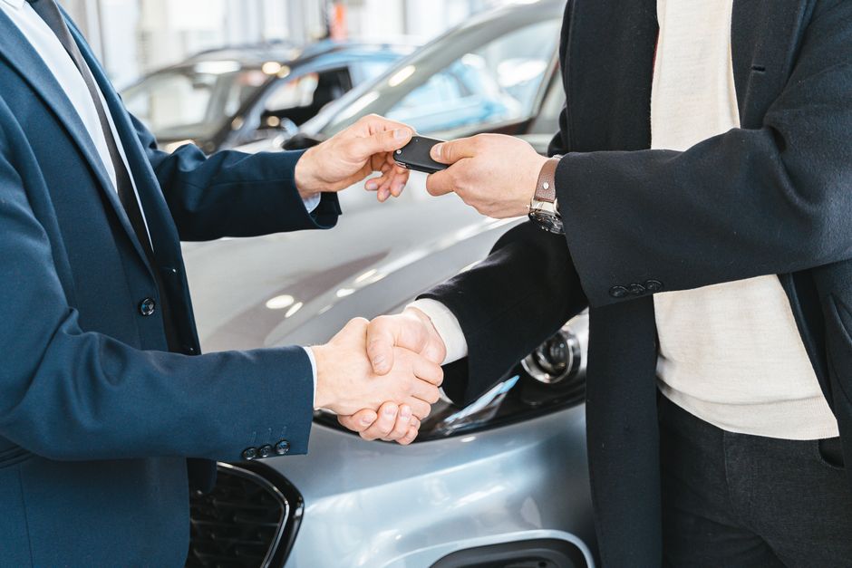 Car buyer shaking hands with a dealer after choosing one of their best used cars under $10,000 near Cumming, GA